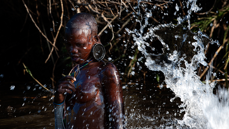 Suri girl enjoying water after the raining season.