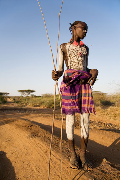 Cow Herder posing at sunset, Omo Valley, Ethiopia. © Andrew Geiger