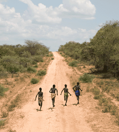 Four boys running down Dirt Road, Omo Valley, Ethiopia. © Andrew Geiger